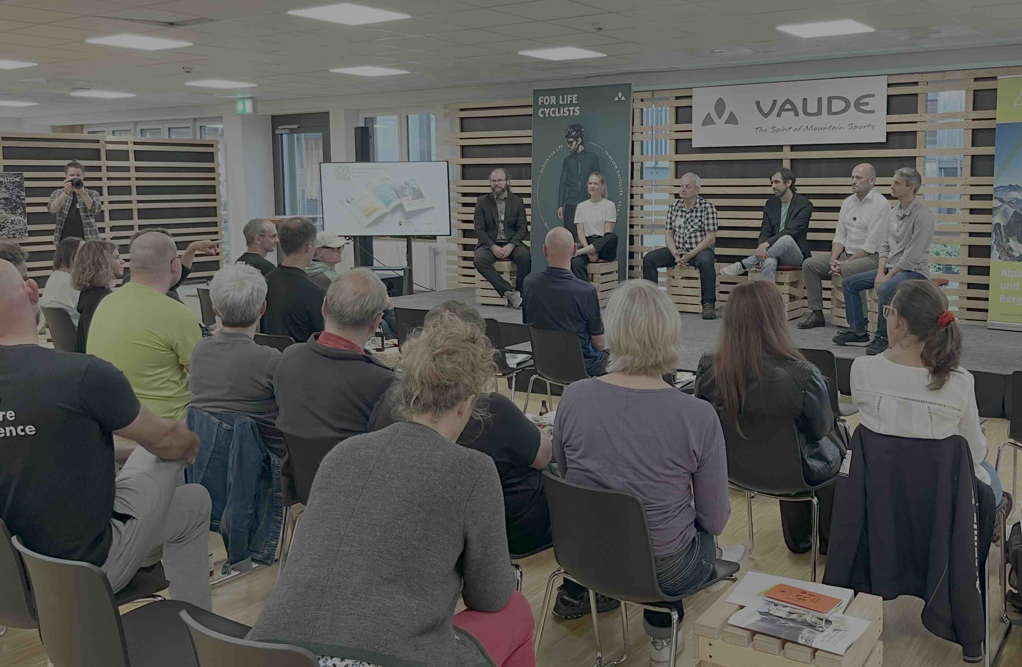 Ein Bild der Veranstaltung mit Podiumsdiskussion auf der Bühne